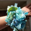 Blue floral wrist corsage with ribbon and greenery