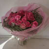 Bouquet of pink roses wrapped in pink paper and clear plastic