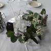 Round table centerpiece with greenery, baby's breath, and glass candle holders