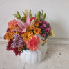 Colorful flower arrangement in a white pumpkin-shaped vase