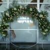 Large floral arch with white and pink flowers on a metal stand