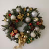 Christmas wreath with ornaments, gift boxes, and gold ribbon