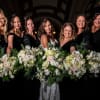 Bridesmaids holding white and blush floral bouquets