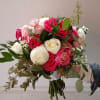 Hand-tied bouquet of pink and white roses with greenery