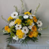 Yellow and white mixed flower arrangement in a clear vase
