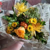 Bouquet of yellow and orange flowers wrapped in printed paper