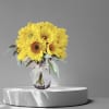 Yellow sunflower bouquet in a glass vase with a ribbon