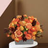 Orange and peach roses in a gray rectangular vase