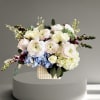 Pastel floral arrangement in a textured square vase