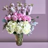 Pink roses and white hydrangeas in a clear glass vase