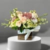 Bouquet of peach and cream roses with pink blooms in a wooden box