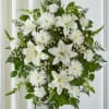 White lilies and daisy-like flowers in a standing arrangement