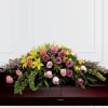 Casket spray with pink and purple roses and yellow lilies