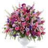 Mixed pink and purple flower arrangement in a white vase