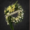 Large floral wreath with yellow lilies and white flowers on a stand