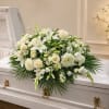 White floral spray on a white casket