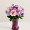 Pink and lavender bouquet in a purple glass vase