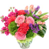 Pink roses, tulips, carnations, and purple filler in a glass vase