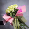 Bouquet of pale yellow roses wrapped in pink paper with a ribbon