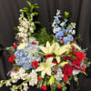 Mixed bouquet with white lilies, blue hydrangeas, red roses, and white stock