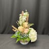 Cream roses and white hydrangeas in a low bowl arrangement