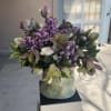 Bouquet of purple flowers and green foliage in a ceramic vase
