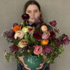 Mixed bouquet in a green ceramic vase with burgundy, pink, orange, and cream blooms