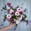 Handheld bouquet of pink, white, and purple flowers