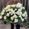 Large basket of white roses held by a person