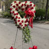 Heart-shaped red and white floral standing arrangement with ribbon