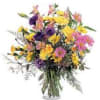Mixed bouquet of yellow, pink, and purple flowers in a glass vase