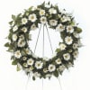 White daisy funeral wreath on a metal stand