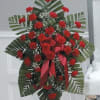 Standing floral spray with red carnations and ribbon accents