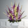 Tall purple and yellow floral arrangement in a white container