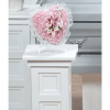Pink floral heart arrangement on a white pedestal