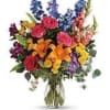 Colorful mixed bouquet with roses, lilies, and snapdragons in a glass vase