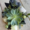 Succulent bouquet with blue thistle and white blooms wrapped in black paper