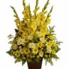 Tall yellow floral arrangement in a brown urn vase