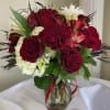 Red roses and white flowers in a glass vase