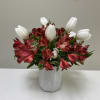 Red alstroemeria and white tulips in a gray vase