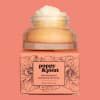 Pink grapefruit lip scrub in a jar on a peach box