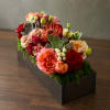 Mixed floral arrangement in a black rectangular box with succulents and roses