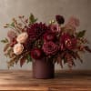 Burgundy and blush floral arrangement in a round vase