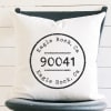 White pillow with black Eagle Rock, CA 90041 print on a dark chair