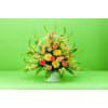 Mixed flower arrangement in a white basket with pink and yellow blooms