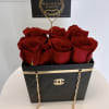Six red roses in a black gift box with a gold chain and card topper