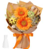 Bouquet of orange and yellow flowers wrapped in brown paper with an orange ribbon