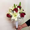 Handheld bouquet of red roses and white lilies with baby's breath