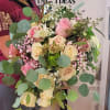 Handheld bouquet of pink and cream roses with eucalyptus and baby's breath