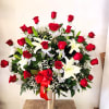 Large arrangement of red roses and white lilies in a tall vase